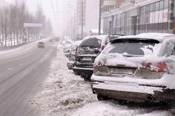 Karla kaplı bir caddeye park edilmiş arabalar. Kar fırtınası, Kyiv, Ukrayna üstüne şehir