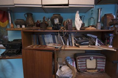 Eski paslı ütüler, eski fotoğraf makinesi ve kırsal bir evdeki masaya konmuş diğer ıvır zıvırlar. Ukrayna 'nın Khotiv köyü