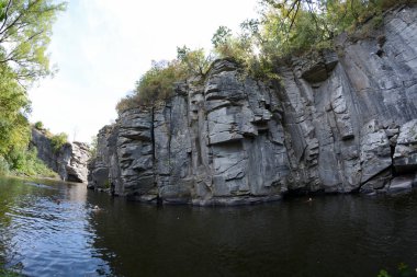 İnsanlar Buksky Kanyonu 'nun kayalıklarının önünde nehirde yüzüyorlar. 27 Ağustos 2019. Çerkaskaya oblast, Ukrayna