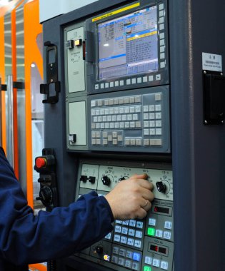 İşçi el, Fanuc 'un yaptığı torna tezgahının bilgisayar sayısal kontrolü düğmesini çeviriyor. 19 Kasım 2019. Kyiv, Ukrayna