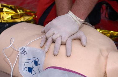 Acil servis çalışanı, yüzüne oksijen yastığı tutarak, hastaların göğsüne baskı yapıyor. Yapay solunum