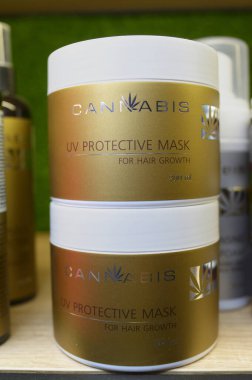 Esrar özlü kozmetik ürünleri. UV koruyucu maskeli plastik teneke kutular bir dükkanın tezgahına yerleştirilmiş kıllar için. Esrar fuarı. 2 Ekim 2020. Kyiv, Ukrayna