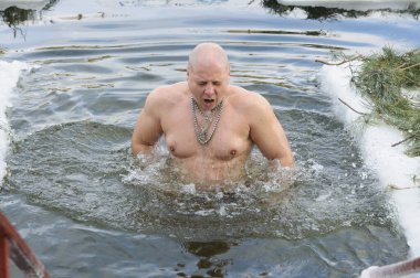 Orta yaşlı, kalın elbiseli kadınlar vaftiz töreninden sonra röportaj veriyorlar. Büyük baş parmaklar iyi hissettiklerini gösteriyor. Dnipro Nehri 'nde Epifani bayramı. 19 Ocak 2019. Kyiv, Ukrayna