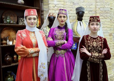 Geleneksel Tatar elbiseli üç genç kadın, arka planda mutfak aletleri. Outlook Dünya Kültür Festivali. 27 Ekim 2018. Kiev, Ukrayna