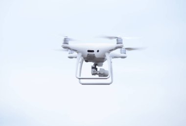 Gökyüzünde uçan kameralı bir kuadkopter.