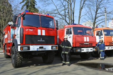 İtfaiyeciler eğitimden önce itfaiye arabalarının yanında dururlar. 5 Nisan 2019. Sviatoshyn Bölgesi Ormanı, Kyivska oblast, Ukrayna