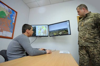 İtfaiye video gözlem odasında: monitörlerin önünde oturan operatör ormanlardaki yangın tehlikelerini gözlemliyor. 5 Nisan 2019. Sviatoshyn Bölgesi Ormanı, Kyivska oblast, Ukrayna