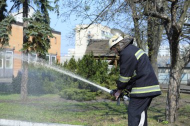 İtfaiyeci itfaiyeciler itfaiye aracının yanında yangın söndürme ekipmanı hazırlıyor. 5 Nisan 2019. Sviatoshyn Bölgesi Ormanı, Kyivska oblast, Ukrayna