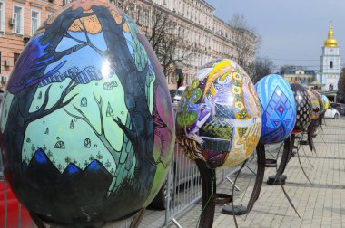 Meydanda büyük boyalı Paskalya yumurtası tesisleri, etrafta dolaşan insanlar. Halk sanatı festivali. 18 Nisan 2018. Kyiv, Ukrayna
