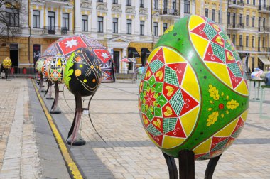 Meydanda büyük boyalı Paskalya yumurtası tesisleri, etrafta dolaşan insanlar. Halk sanatı festivali. 18 Nisan 2018. Kyiv, Ukrayna