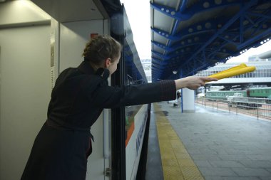 Tren kondüktörü, yolcu treninin peronda durduğunu bildiriyor. 22 Aralık 2019. Grand Central tren istasyonu. Kiev, Ukrayna