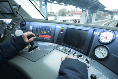 Yolcu treninin kabininde. Konsolun önünde lokomotif başında oturan tren sürücüsü ve kolu çalıştırma koluna koyuyor