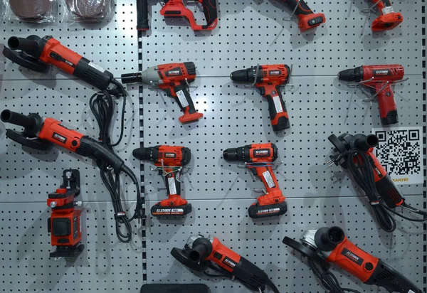 Elektrikli matkaplar, kablosuz tornavidalar, anahtarlar, el değirmenleri ve bir dükkanın tezgahına yerleştirilmiş diğer elektrikli aletler. Endüstri fuarı. 17 Kasım 2021. Kyiv, Ukrayna