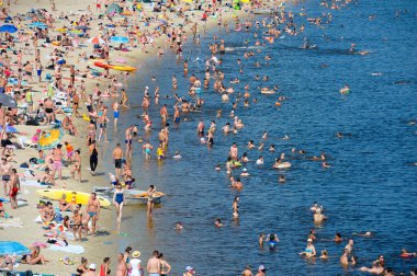 Plaj, güçlü sıcaklık. Güneşlenen ve suda yüzen bir sürü insan. 10 Haziran 2021. Hidropark, Kyiv, Ukrayna