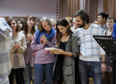 Krishna cemaati bir yerde oturup kitaptan mantralar okuyor. 3 Nisan 2013. Kiyv, Ukrayna