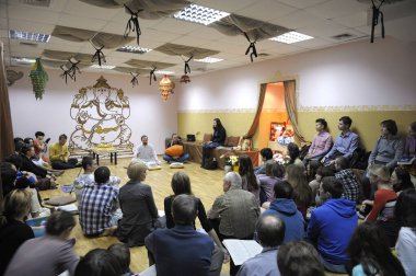 Krishna parishioners sitting on a floor and listening to guru. April 3, 2013. Kiyv, Ukraine clipart