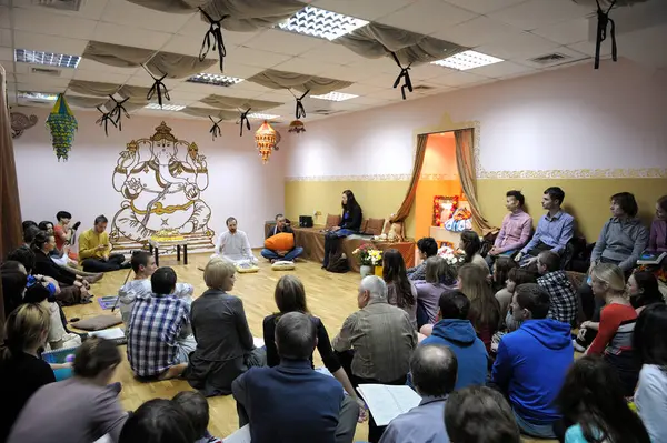 Krishna cemaati bir yerde oturup guru dinliyor. 3 Nisan 2013. Kiyv, Ukrayna