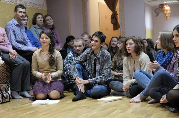 Krishna cemaati bir yerde oturup guru dinliyor. 3 Nisan 2013. Kiyv, Ukrayna