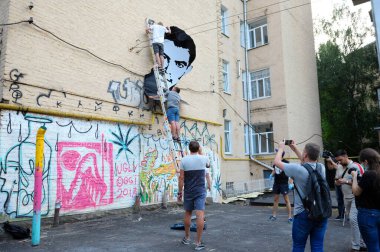 Genç eylemciler binanın duvarına ünlü Ukraynalı şair ve muhalif Vasyl Stus 'un poster portresini astılar. 12 Haziran 2018. Kyiv, Ukrayna