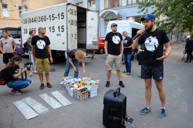 Protesto eylemine hazırlanan gençler asfalta Putin 'e karşı saldırgan harfler çiziyorlar. Vasyl Stus 'un posterini asma eylemi. 12 Haziran 2018. Kyiv, Ukrayna