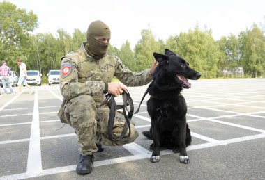 Üniformalı KORD birliğinin (Ukrayna SWAT) askeri ve yerde oturan polis köpeği. 5 Eylül 2018. Kiev, Ukrayna