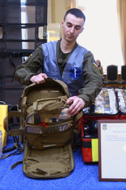 Asker Ukraynalı sıhhiyeci sırt çantasında asker ilk yardım çantası sunuyor: bandajlar, yaraları iyileştiren ilaçlar, yanık tedavi jeli ile balon, ağrı kesici. 7 Ekim 2018. Kyiv, Ukrayna