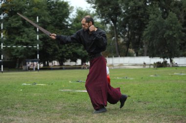 Ukraynalı savaşçı Kozak gibi giyinmiş bir adam kılıç eğitimi veriyor. 20 Haziran 2019. Kyiv, Ukrayna