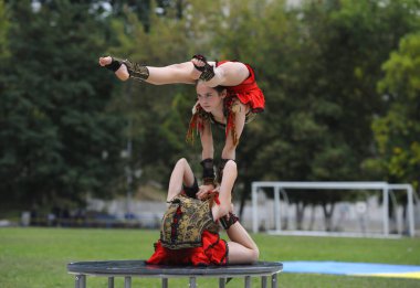 Genç kız akrobatlar bir stadyumda akrobatik dublörlük yapıyorlar. 20 Haziran 2019. Kyiv, Ukrayna