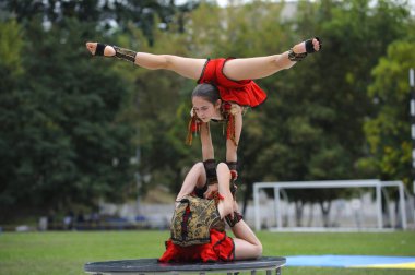 Genç kız akrobatlar bir stadyumda akrobatik dublörlük yapıyorlar. 20 Haziran 2019. Kiev, Ukrayna