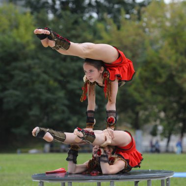 Genç kız akrobatlar bir stadyumda akrobatik dublörlük yapıyorlar. 20 Haziran 2019. Kyiv, Ukrayna