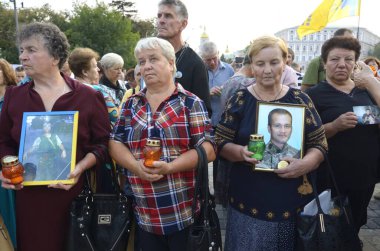 Yas tutan kadın anneler ve eşler ağlıyor ve ellerinde askerlerin portrelerini tutuyorlar. Ilovaisk savaşının yıldönümüne adanmış bir toplantı. 28 Ağustos 2018. Kyiv, Ukrayna