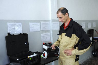 Radyasyon detektörleri test ediyor. Dosimetri uzmanı elinde el yapımı radyasyon izotop tanımlayıcısı, arka planda kara kutular tutuyor. 1 Ekim 2018. Devlet şirketi Radon. Kyiv, Ukrayna