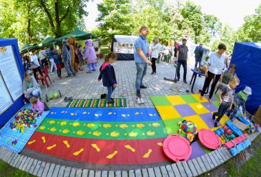 Aileler babalarının çocukları parktaki süslü oyun parkında oynuyorlar. Anneler Günü. 12 Mayıs 2019. Kyiv, Ukrayna