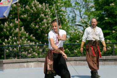 Belediye parkında Anma Günü 'ne adanmış toplantı sırasında Ukrayna' da geleneksel Kazak kostümlü erkekler kılıç dansı yapıyorlar. 8 Mayıs 2019. Kyiv, Ukrayna
