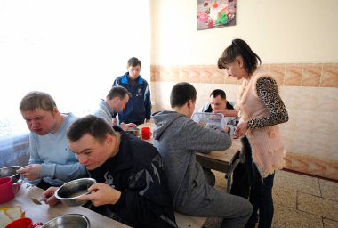 Engelli çocuklar için yatılı okulun kantininde. Down sendromlu çocuklar yemek yerken garsonluk yapıyor. 12 Şubat 2019. Kiev, Ukrayna