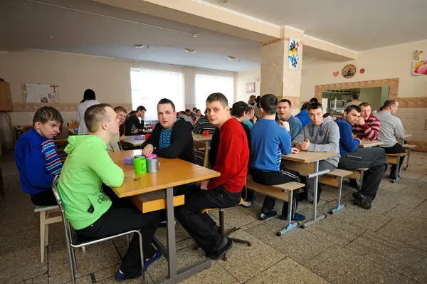 Engelli çocuklar için yatılı okulun kantininde. Down sendromlu çocuklar akşam yemeğinden önce masada otururlar. 12 Şubat 2019. Kiev, Ukrayna