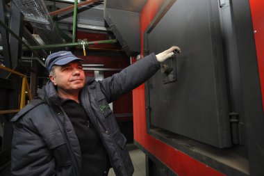 Buhar üreten gemiyi kontrol eden bir işçi, modern şehir kazan dairesinde çalışıyor. 21 Kasım 2017. Slavutich, Ukrayna