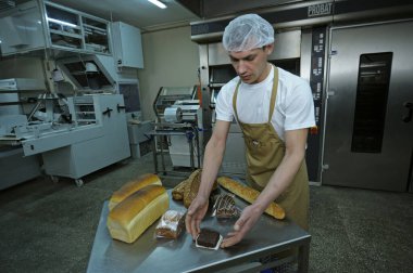 Hollanda fırınında fırıncı fırın ürünlerini sunar: Hollanda ekmekleri, ekmekler, kekler. 21 Mart 2018. Brovary Ukrayna