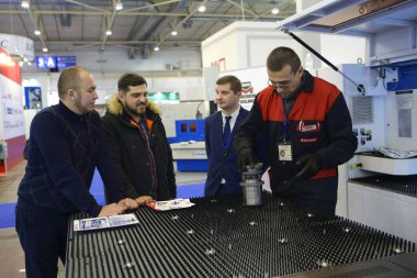 Yönetici kürsüdeki ziyaretçi modern ekipmanlara sunum yapıyor. Endüstri Sergisi. 23 Kasım 2020. Kyiv, Ukrayna.