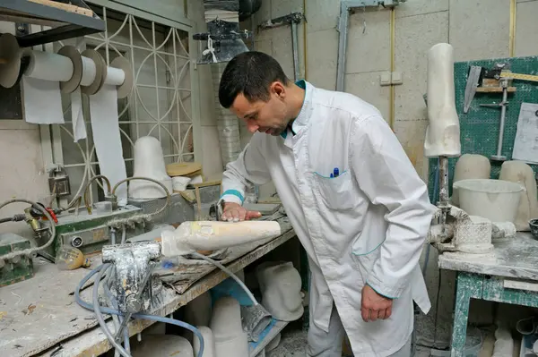 Stock image Man worker making artificial limbs for further manufacturing prosthesis, orthopedic workshop. January 19, 2020. Kyiv, Ukraine