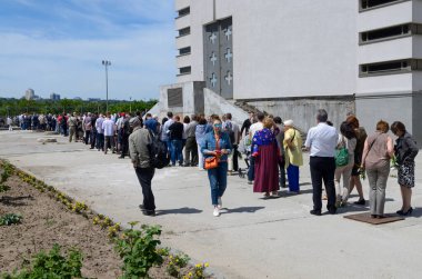 İnsanlar Pazar ayini için Katolik kilisesine girmek için sırada bekliyorlar. 5 Mayıs 2017. Kiev, Ukrayna