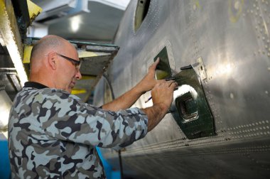 Uçak tamiri yapılıyor. İşçi, bir ceset uçağını örtmek için metal levha işaretlemiş. 8 Haziran 2018. Kiev, Ukrayna