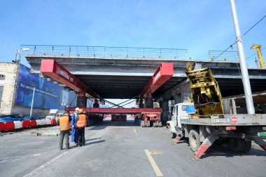 Süper Jack Mammoet onu kaldırmak için eski bir köprü bölümünü tutuyor. Shuliavskiy üst geçidinin yıkılması. 17 Nisan 2019. Kyiv, Ukrayna