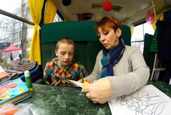 stock image Teacher showing children how to make an appliques. Club and library for children in the converted streetcar. March 26, 2019. Kyiv, Ukraine