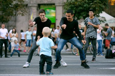Genç sokak dansçıları erkek kızlar sokakta gösteri yapıyor, arka planda bir sürü insan var. 3 Temmuz 2019. Khreshhatyk, Kyiv, Ukrayna