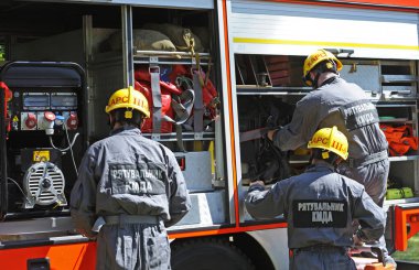 İtfaiye aracı park etmiş, itfaiyeciler yangın söndürme ekipmanlarını kullanıma hazırlıyor. 5 Haziran 2019. 2019. Kievskaya oblast, Ukrayna