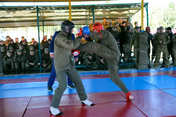 stock image Army combative. Two fighters fighting in a ring, referee watching. An exhibition fight between men, officer instructor and trainee soldier, amateurs. October 18, 2018. Novo-Petrivtsi military base, Ukraine