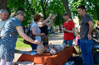 İnsanlar, şehir parkındaki bir masadan Kırım Tatarları seramikleri satan satıcılarla iletişim kuruyor. Etno Festivali. 25 Temmuz 2019. Kyiv, Ukrayna