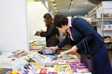Müşteriler kitapçının önünde durup yeni basılmış kitapları okuyorlar. Kitap Fuarı sözleşmeleri. 14 Aralık 2017. Kiev, Ukrayna