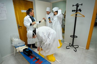 Visitors put protective clothes on to pass to the building of the Chernobyl Nuclear Power Plant. April 20, 2018. Chernobyl, Ukraine clipart